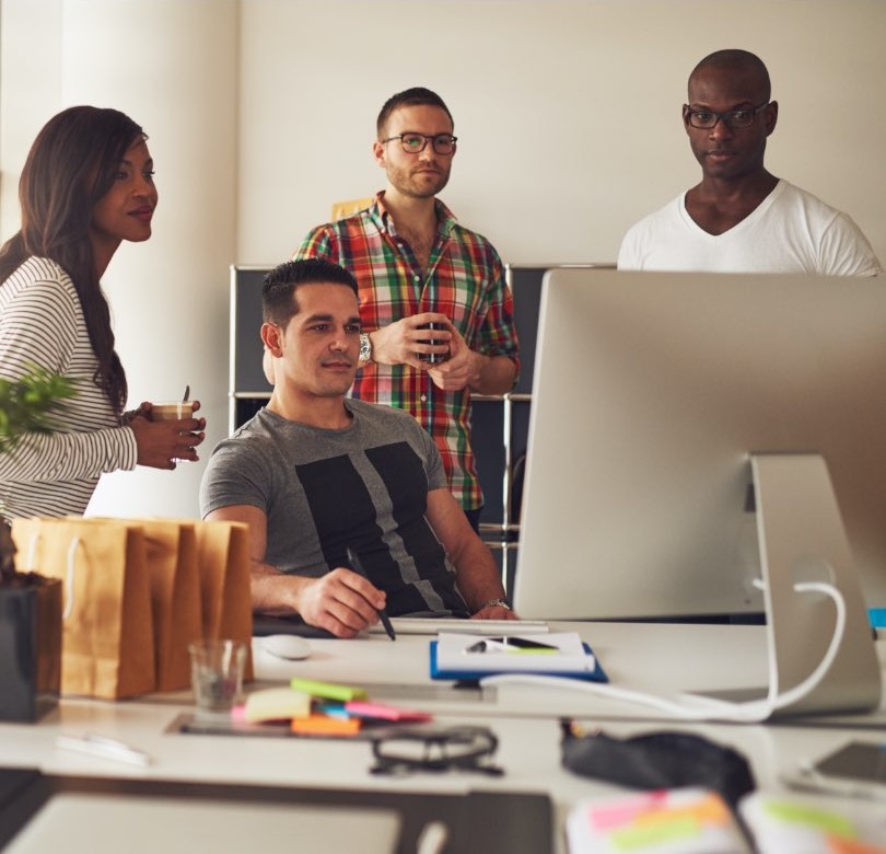 Co-workers reviewing a computer in office.