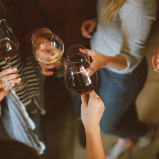 A group of people clinking wine glasses together to cheers