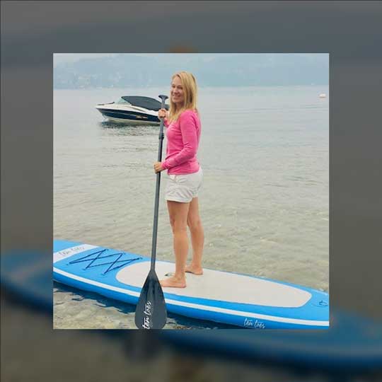 Christine standing on a paddle board.