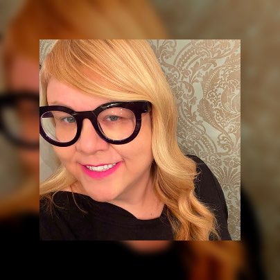 Jodi taking a selfie while wearing thick-rimmed black glasses.