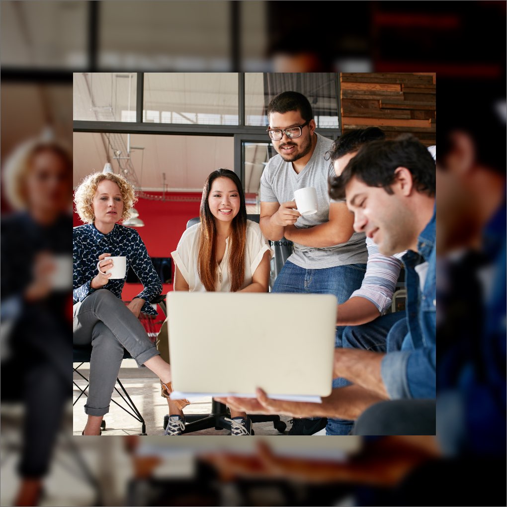 A man showing a presentation on his laptop to a group of coworkers.